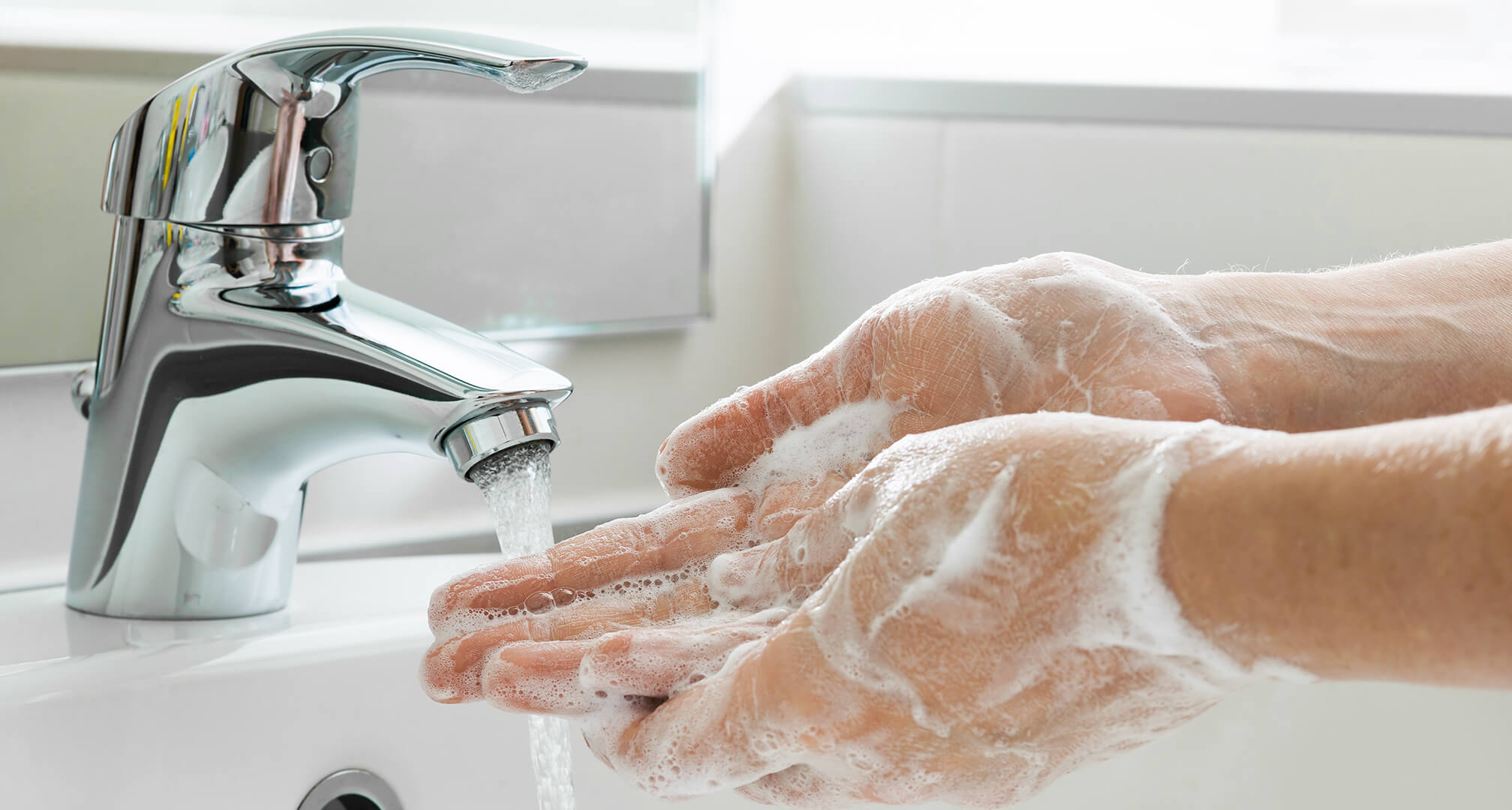 mytí namydlených rukou pod kohoutkem umyvadla