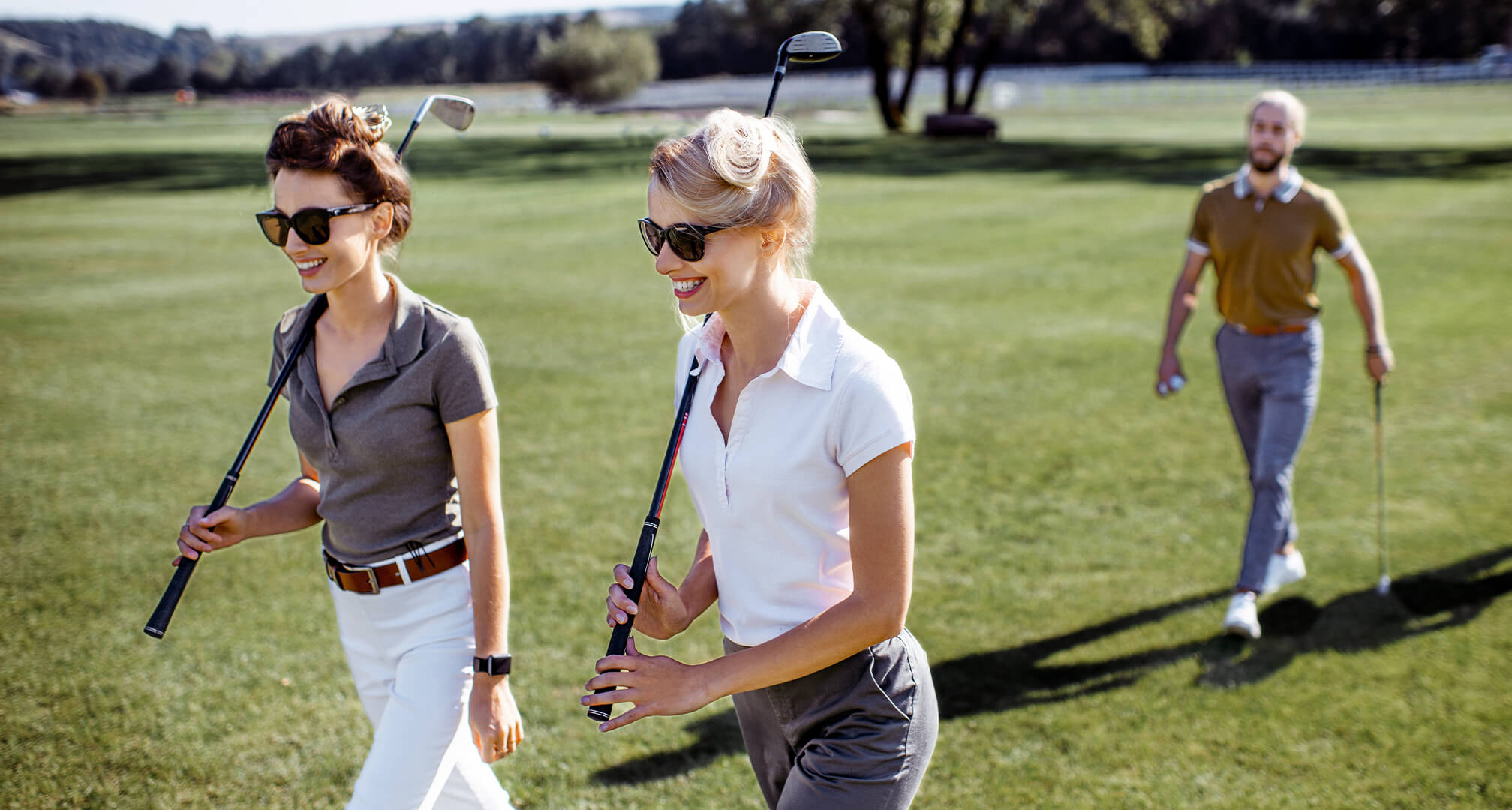 dvě osoby hrající golf se slunečními brýlemi