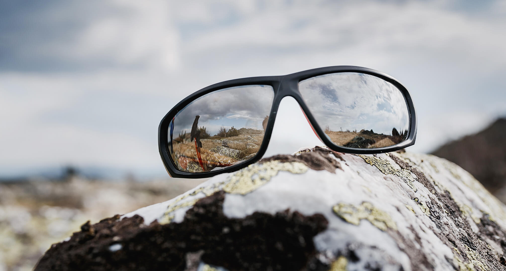 occhiali da sole a specchio poggiati su una roccia
