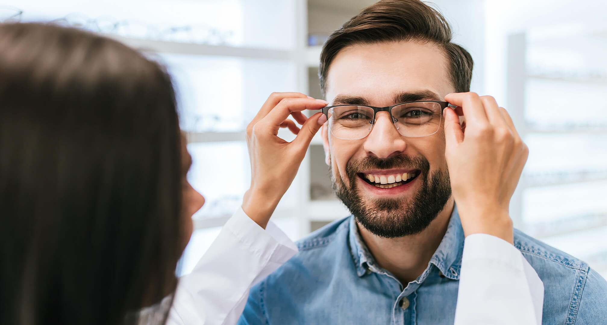 Ein Optiker passt einem Mann die Brille an