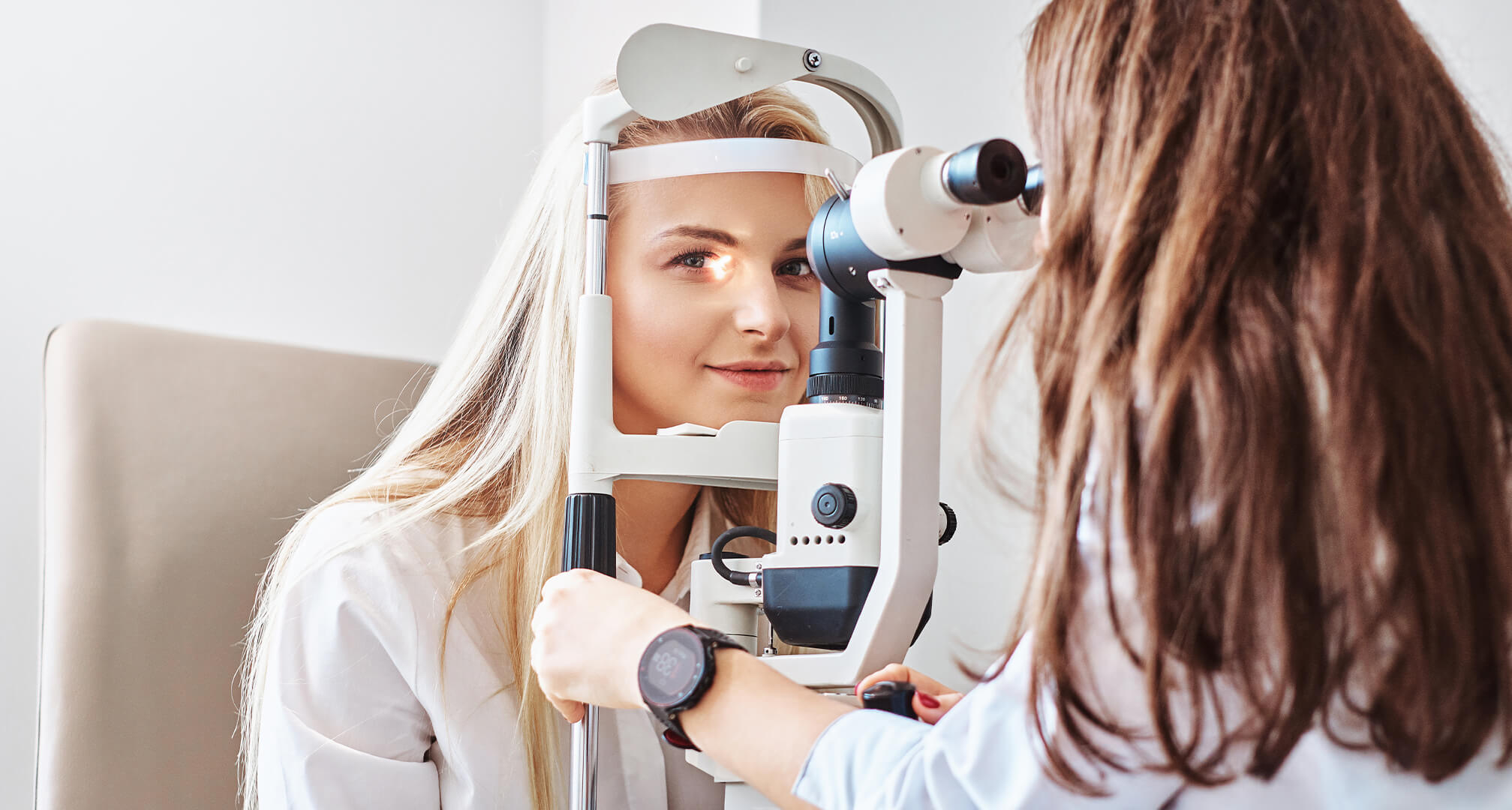 Optometrist die de ogen van de vrouw onderzoekt